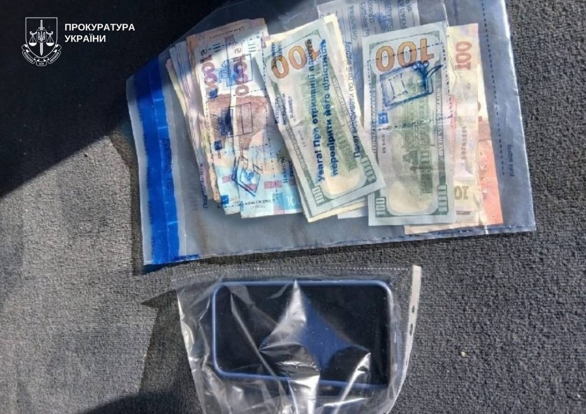 Долари та гривні в пакеті для речових доказів і телефон